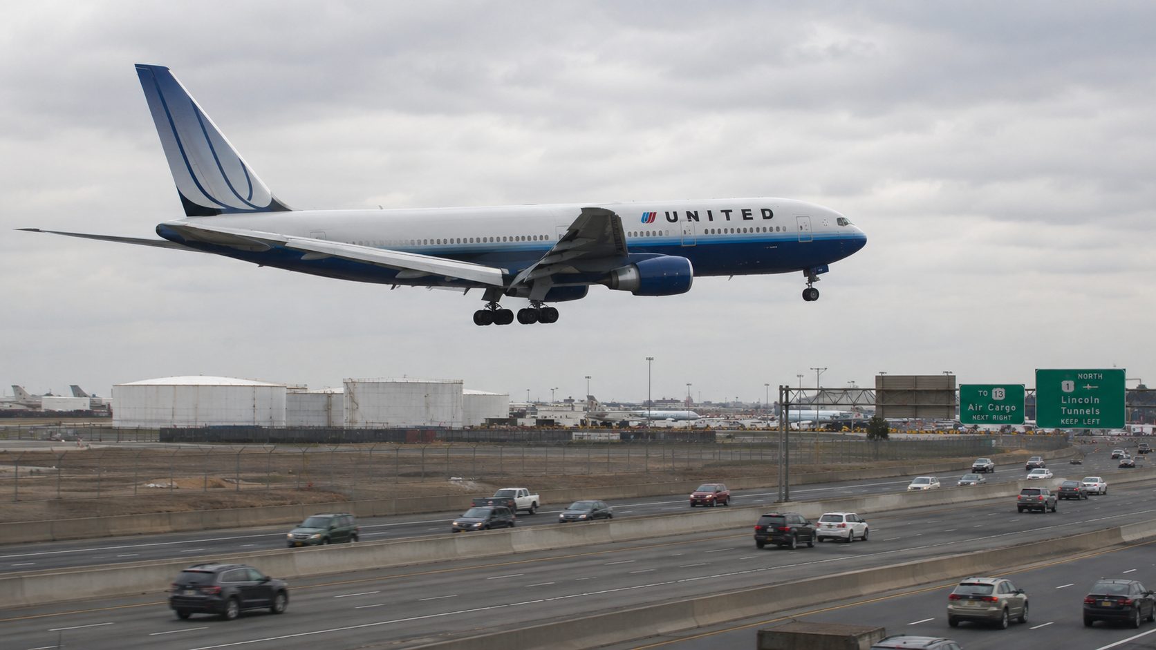 Boeing 767 on low final approach over a highway near Newark Liberty International Airport