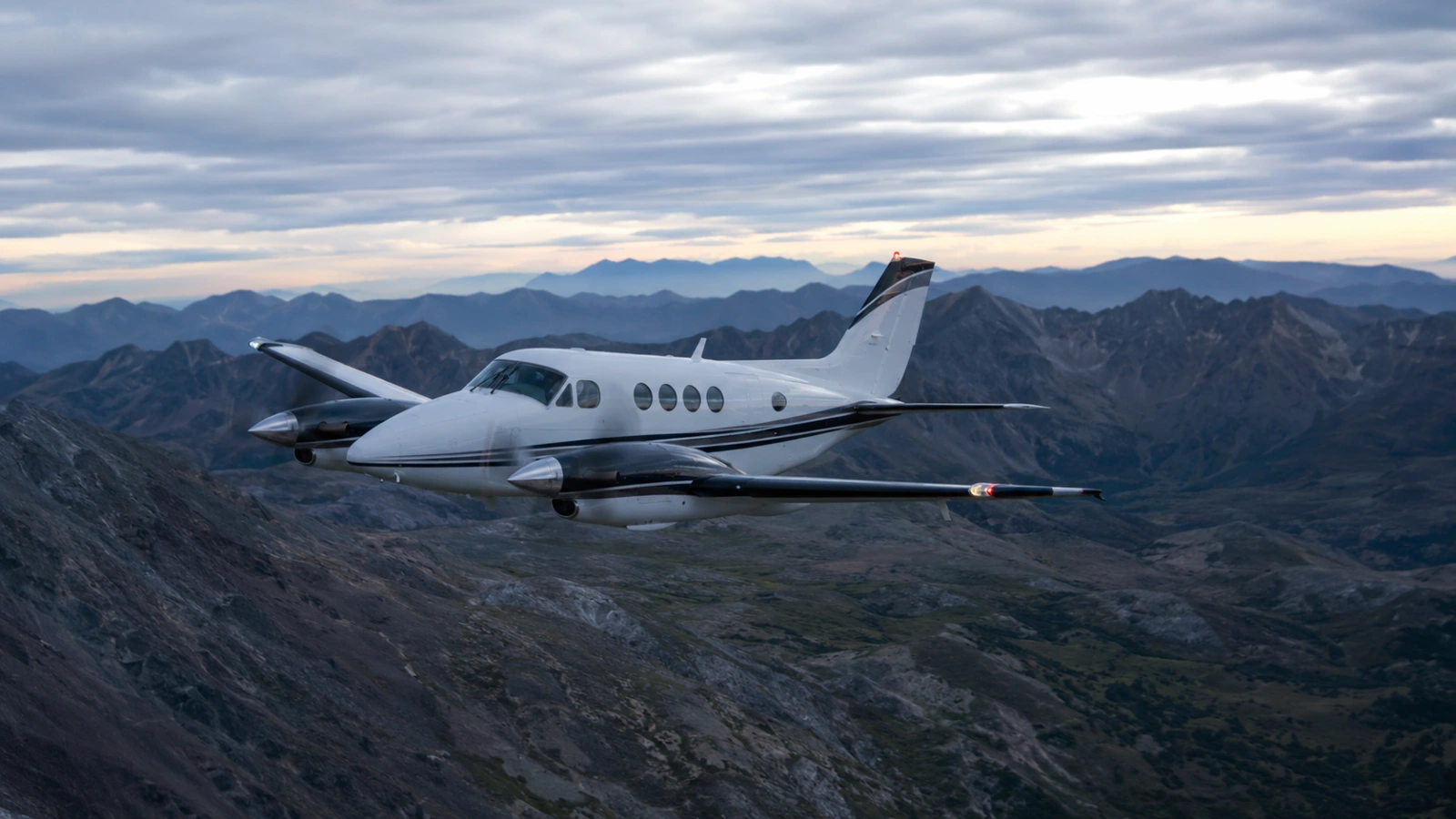 Air Medical Fixed-Wing Transport Beechcraft King Air 90 flying over mountainous terrain